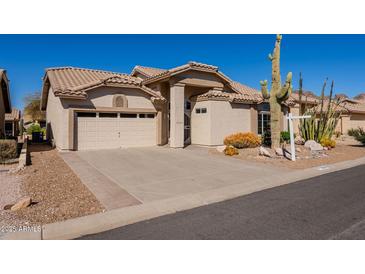 Charming single-story home featuring desert landscaping, a spacious driveway, and a neutral-toned facade at 8582 E Brittle Bush Rd, Gold Canyon, AZ 85118