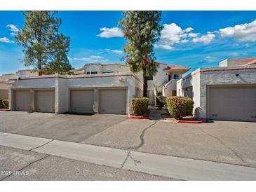 Charming townhome featuring multiple units, garages, and beautiful desert landscaping on a sunny day at 985 N Granite Reef Rd # 127, Scottsdale, AZ 85257
