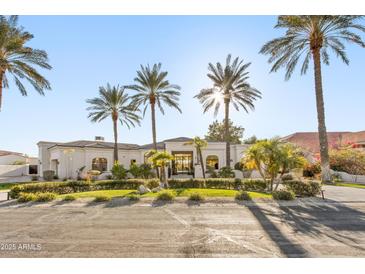 Stunning white stucco home with meticulously landscaped yard and towering palm trees at 10800 E Cactus Rd # 38, Scottsdale, AZ 85259