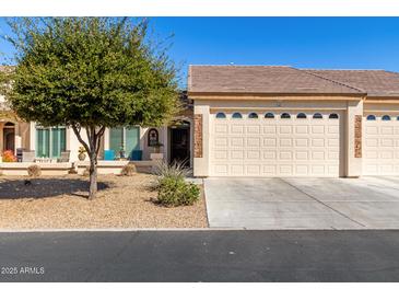 Charming home featuring a xeriscaped front yard, covered porch with comfortable seating, and attached two-car garage at 10960 E Monte Ave # 242, Mesa, AZ 85209