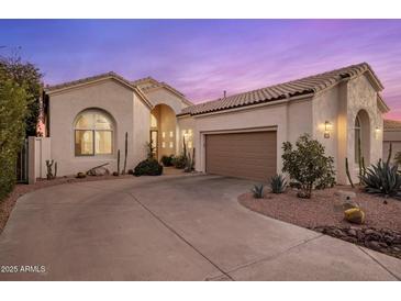 Charming stucco home featuring a two-car garage and desert landscaping for a clean, modern look at 11627 E Bella Vista Dr, Scottsdale, AZ 85259