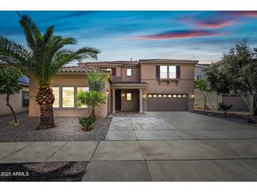 Beautiful home with a landscaped front yard, desert landscaping, and an attached two car garage at 13569 W Ventura St, Surprise, AZ 85379