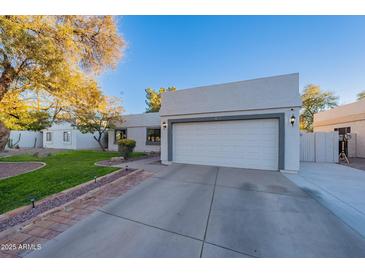 Charming home featuring a well-manicured lawn and a two-car garage with a large driveway at 1601 E Elgin St, Chandler, AZ 85225