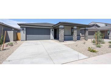 Charming single-story home with a stone-accented porch and a spacious driveway at 17996 W Camino De Oro --, Surprise, AZ 85387