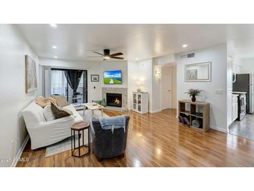 Inviting living room features a cozy fireplace and a sliding glass door to a private balcony at 2025 E Campbell Ave # 227, Phoenix, AZ 85016