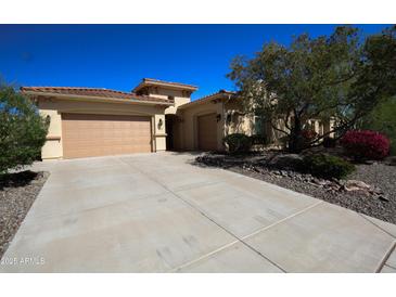 Charming single-story home featuring a tile roof, desert landscaping, and a spacious driveway at 31483 N 133Rd Dr, Peoria, AZ 85383
