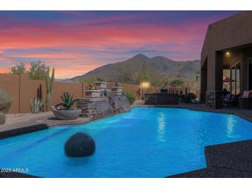 Inviting pool with water feature set against the backdrop of a desert mountain at 35345 N Canyon Creek Ct, Carefree, AZ 85377