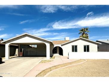 Charming single-story home with a neutral facade, covered parking and desert landscaping at 4038 E Burgess Ln, Phoenix, AZ 85042