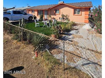 Charming single-story home featuring a well-maintained front yard with seating area and desert landscape at 4654 S 17Th St, Phoenix, AZ 85040