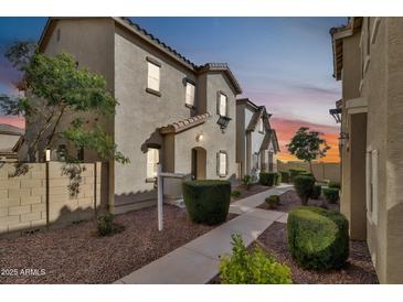 Charming townhome boasts a landscaped front yard and inviting entrance at twilight at 4669 E Olney Ave, Gilbert, AZ 85234