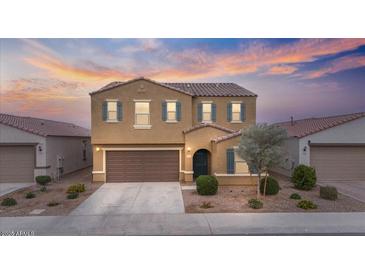 Charming two-story home featuring a tile roof, blue shutters, and a neatly landscaped front yard at 618 E Elm Ln, Avondale, AZ 85323