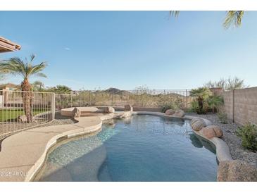 Inviting pool with rock features and desert views, perfect for relaxation and entertaining in the Arizona sun at 7355 W Red Hawk Dr, Peoria, AZ 85383