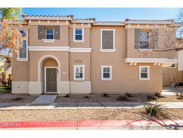 Charming two-story home featuring an arched entryway and desert landscaping at 923 W Wendy Way, Gilbert, AZ 85233