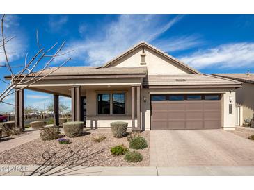 Charming single-story home featuring a covered porch, desert landscaping, and a two-car garage at 9716 E Resistance Ave, Mesa, AZ 85212