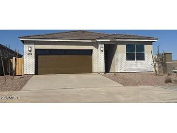 Charming single-story home with a two-car garage and a well-maintained front yard at 18334 W Desert Holw Dr, Wittmann, AZ 85361