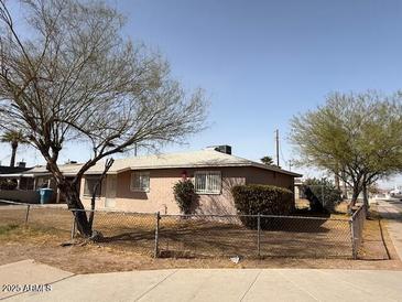 Modest single-story home with simple landscaping and a chain-link fence at 1950 E Wier Ave, Phoenix, AZ 85040