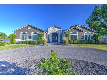 Elegant single-story home with a circular driveway and manicured landscaping at 22406 S 173Rd Way, Gilbert, AZ 85298