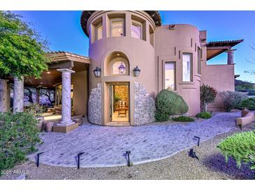 Inviting home exterior with stone accents, arched entryway, and beautifully landscaped walkway, offering elegance at 28503 N 104Th Way, Scottsdale, AZ 85262