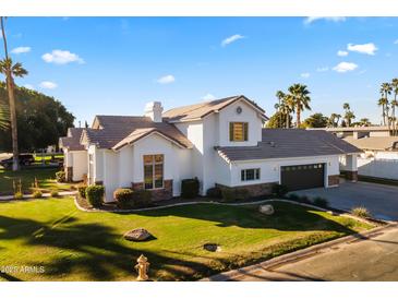 Charming two-story home with manicured lawn, lush landscaping, and a two car garage at 302 W Stella Ln, Phoenix, AZ 85013