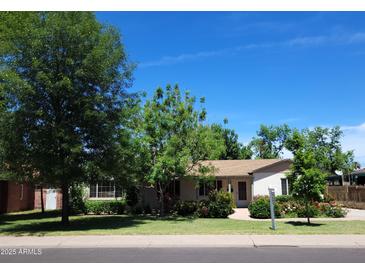 Charming single-story home featuring a lush green lawn and beautiful garden landscaping under a clear blue sky at 32 E 14Th St, Tempe, AZ 85281
