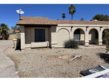 Beige single-story home with a brown roof and minimal landscaping in a sunny, clear-sky setting at 5114 W Joan De Arc Ave, Glendale, AZ 85304