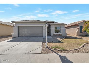 Charming single-story home with a gray exterior, well-manicured yard, and a two-car garage at 9121 W Alvarado St, Phoenix, AZ 85037