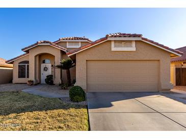 Charming single-story home featuring a tile roof, two-car garage, and well-manicured landscaping at 9853 W Irma Ln, Peoria, AZ 85382