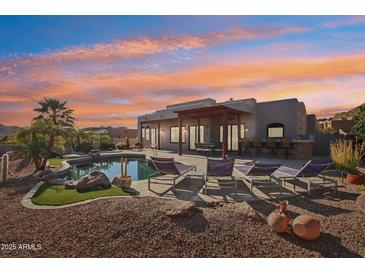 Inviting backyard featuring a pool, covered patio, lounge chairs, and desert landscaping at 9870 E Little Nugget Way, Gold Canyon, AZ 85118