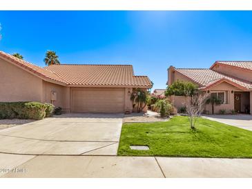 Charming single-story home featuring a well-manicured lawn, mature landscaping, and a two-car garage at 13425 N 92Nd Pl, Scottsdale, AZ 85260