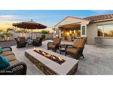 Inviting backyard patio with a cozy fire pit and comfortable seating, perfect for outdoor relaxation at 13583 S 177Th Ln, Goodyear, AZ 85338