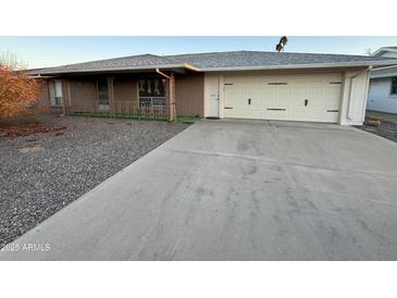 Charming single-story home featuring a well-maintained front yard and an attached two-car garage with a large concrete driveway at 13846 N Tan Tara Dr, Sun City, AZ 85351