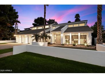 Striking home exterior showcases clean lines, desert landscaping, and a private courtyard under a colorful sky at 25 W Frier Dr, Phoenix, AZ 85021