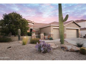 Charming desert home with a landscaped front yard, three car garage, and beautiful sunset sky at 4251 E Desert Forest Trl, Cave Creek, AZ 85331