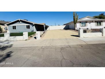 Charming home showcasing a low white fence and desert landscaping for low maintenance appeal at 4836 W Redfield Rd, Glendale, AZ 85306