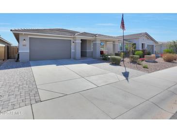 Charming single-story home with a well-manicured lawn, desert landscaping and covered entryway at 5121 N 181St Dr, Litchfield Park, AZ 85340