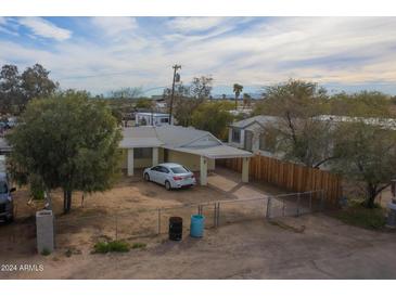 Charming single-story home featuring a covered carport, fenced yard, and mature trees at 5907 N Azalia St, Casa Grande, AZ 85122