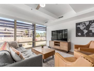 Bright living room with large windows, comfortable seating, and modern entertainment center at 7161 E Rancho Vista Dr # 2015, Scottsdale, AZ 85251