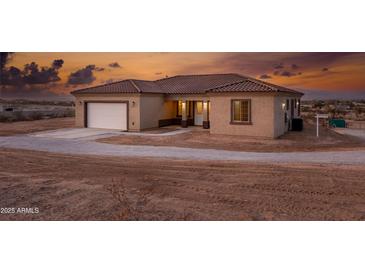 Inviting home featuring a neutral stucco exterior, tile roof, and attached two-car garage at 12942 S 218Th Ave, Buckeye, AZ 85326