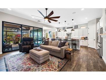 Open-concept living room and kitchen with a ceiling fan and sliding glass doors to the backyard at 2034 N Dome Rock --, Mesa, AZ 85207