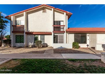 Two-story home featuring a white stucco facade, red tile roof, and a small front yard with desert landscaping at 2842 E Beck Ln # 2, Phoenix, AZ 85032
