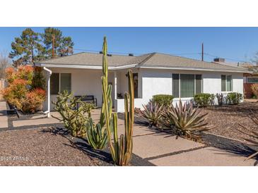 Charming home with desert landscaping featuring saguaro cacti and a lush bush at 2902 E Avalon Dr, Phoenix, AZ 85016