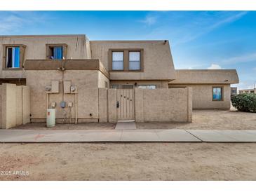 Inviting exterior of home with a unique facade, desert landscaping, and gated front courtyard at 4436 E Pueblo E Ave, Phoenix, AZ 85040