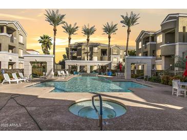 Resort-style pool area with palm trees, lounge chairs, and jacuzzi, creating a relaxing oasis at 5303 N 7Th St # 215, Phoenix, AZ 85014