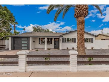 Charming home featuring a modern garage door, fresh white paint and desert landscaping at 6926 E Moreland St, Scottsdale, AZ 85257