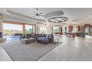 Expansive living room boasts an open layout, tile floors, fireplace, and access to outdoor patio with views at 15827 E Firerock County Club Dr, Fountain Hills, AZ 85268
