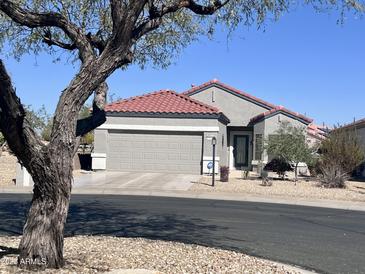 Charming single-story home with a two-car garage and well-maintained desert landscaping at 15876 W Alpine Ridge Dr, Surprise, AZ 85374