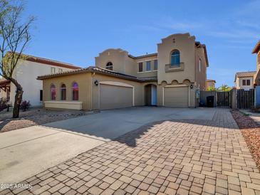 Stunning two-story home featuring a three-car garage and a spacious driveway with beautiful brick accents at 16247 W Desert Mirage Dr, Surprise, AZ 85379