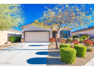 Charming single-story home featuring a well-manicured lawn and a two car garage at 17563 W Summit Dr, Goodyear, AZ 85338