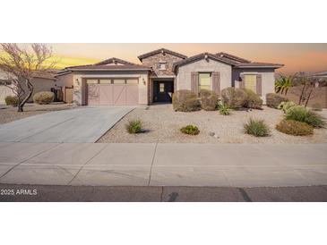 Charming single-story home with desert landscaping, neutral stucco, and a two-car garage at 18406 W Verbena Dr, Goodyear, AZ 85338