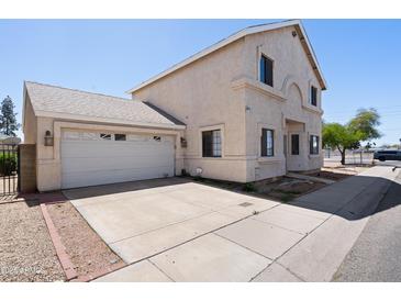 Charming two-story home featuring an attached two-car garage and a concrete driveway at 2051 W Ronald Rd, Phoenix, AZ 85029